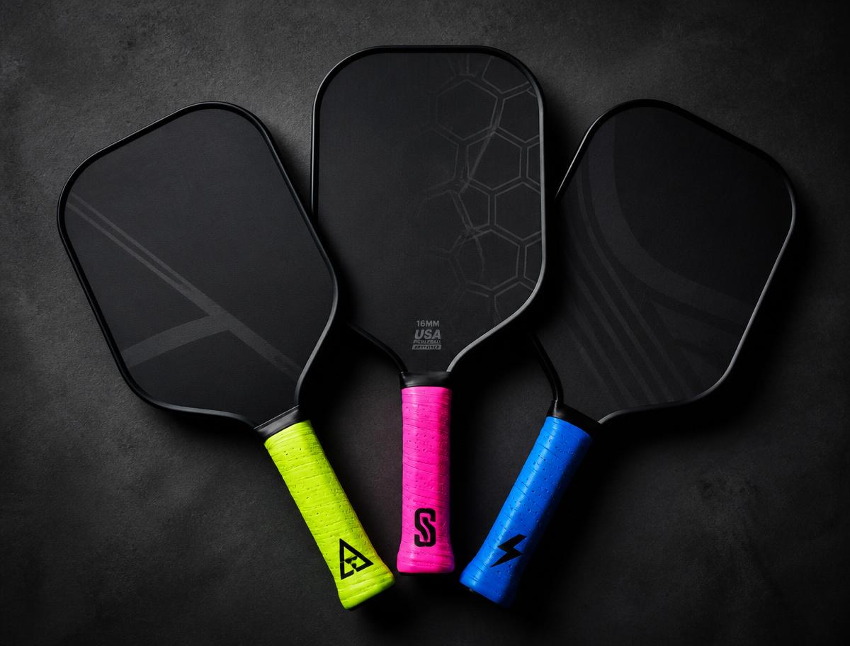 Three custom pickleball paddles with neon lime, hot pink, and electric blue Chef overgrips